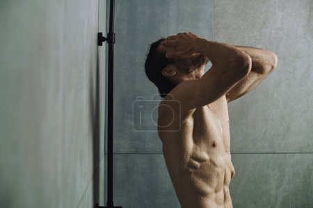 Hemdloser Mann duscht und bereitet sich auf den Tag vor.
