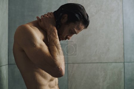 Téléchargez les photos : Homme torse nu dans la salle de bain, se préparant pour la journée avec routine du matin et douche. - en image libre de droit
