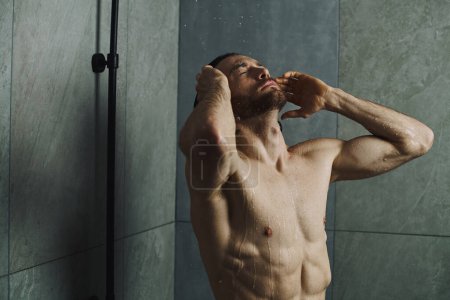 Mann unter der Dusche während der Morgenroutine.