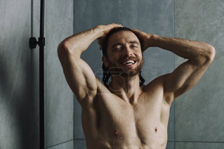Foto de Hombre sin camisa en casa, realizando rutina matutina, de pie frente a una ducha. - Imagen libre de derechos