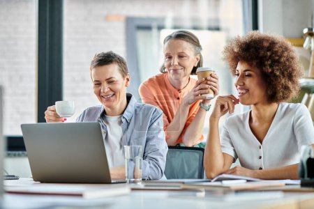 Téléchargez les photos : Groupe diversifié de femmes d'affaires travaillant ensemble sur un ordinateur portable à une table. - en image libre de droit