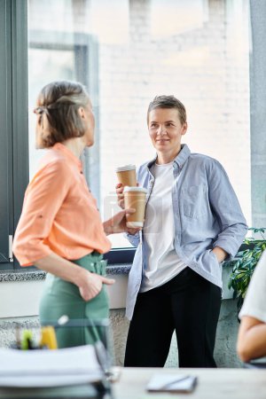 Photo for Two diverse businesswomen enjoying coffee together in a coworking space. - Royalty Free Image