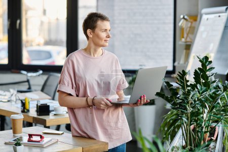 Engagierte Geschäftsfrau konzentriert sich auf ihren Laptop in einem modernen Büroumfeld.