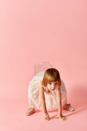 Little girl in white dress posing in motion on pink backdrop.