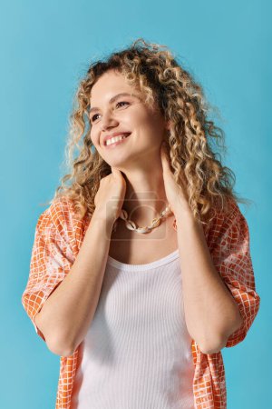 Photo for Young woman with curly hair striking pose against vibrant blue background. - Royalty Free Image