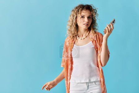 Curly-haired beauty holding smartphone gracefully.