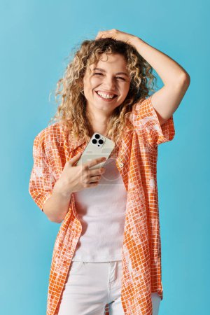 Photo for Young woman with curly hair holding her cell phone. - Royalty Free Image