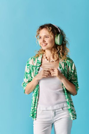 A young woman with headphones poses against a blue background.