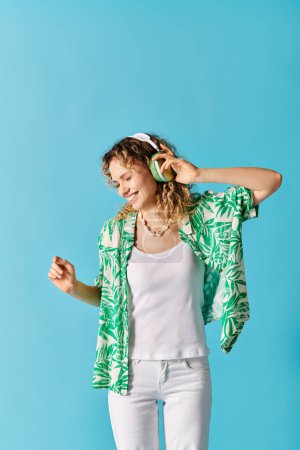 Téléchargez les photos : Femme élégante en chemise verte et pantalon blanc, à l'écoute de la musique. - en image libre de droit