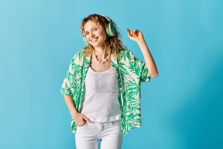 Young woman with headphones in green shirt and white pants.