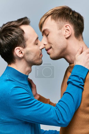 Foto de Dos hombres con atuendo casual se paran uno al lado del otro en el fondo gris. - Imagen libre de derechos