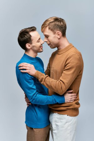 Foto de Dos hombres con atuendo casual abrazándose en una postura amorosa. - Imagen libre de derechos