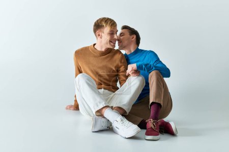 Téléchargez les photos : Deux hommes assis, bras enlacés dans l'amour et la camaraderie. - en image libre de droit