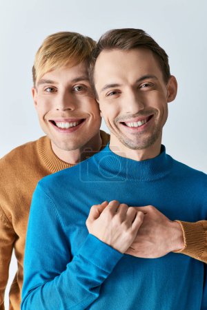 Zwei Männer in legerer Kleidung, die sich mit den Armen um die Schultern umarmen.
