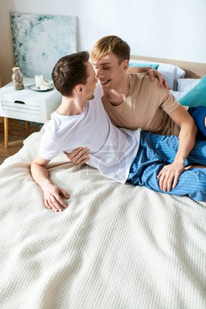 Téléchargez les photos : Un couple gay aimant en tenue décontractée couché sur un lit ensemble. - en image libre de droit