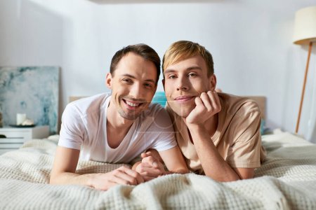 Two men in casual attire lay on a bed, sharing a moment of intimacy and connection.