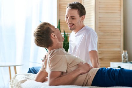 A man receiving a back massage from his partner in a cozy home setting.