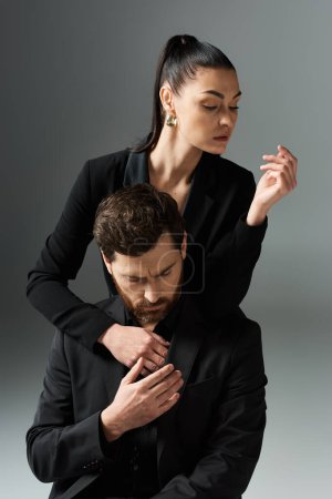 Un hombre tiernamente abraza a la mujer, mostrando su elegante atuendo y amorosa conexión.