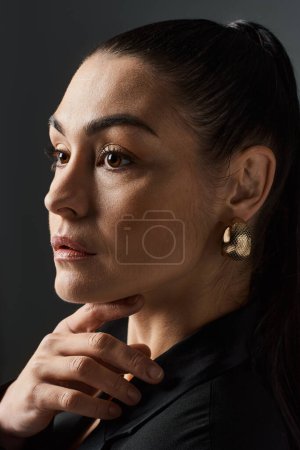 Photo for Elegant woman in black shirt and gold earrings. - Royalty Free Image