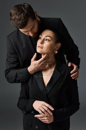 Foto de Un hombre y una mujer en elegante atuendo abrazan amorosamente. - Imagen libre de derechos