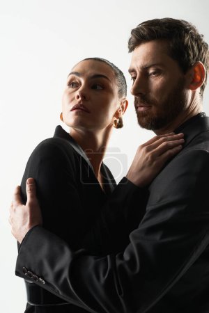 Foto de Hombre y mujer con elegante atuendo, encerrados en un tierno abrazo. - Imagen libre de derechos
