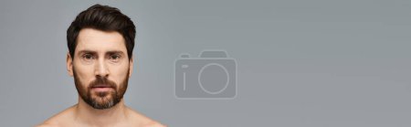 Photo for Handsome man with a beard, shirtless, posing confidently - Royalty Free Image