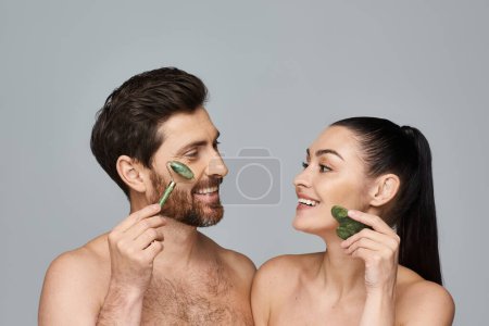 Téléchargez les photos : Un couple, rayonnant de beauté, en utilisant le rouleau de visage et gua sha ensemble. - en image libre de droit