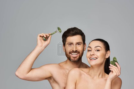 Téléchargez les photos : Alluring couple, radiating beauty, using face roller and gua sha together. - en image libre de droit