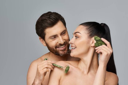 A portrait of an attractive couple applying skincare.