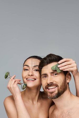 Photo for Merry couple, radiating beauty, using face roller and gua sha together. - Royalty Free Image