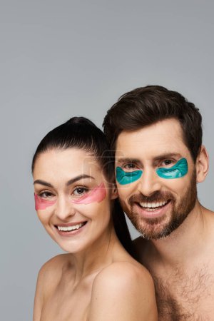 Téléchargez les photos : Couple joyeux, avec des patchs pour les yeux, posent ensemble dans un affichage enchanteur. - en image libre de droit