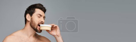 Photo for Shirtless man biting a jar of cream. - Royalty Free Image