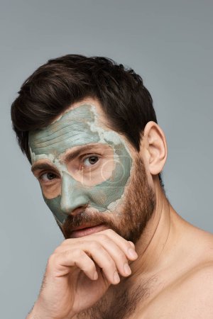 Téléchargez les photos : Un homme portant un masque facial, améliorant sa routine de soins de la peau. - en image libre de droit