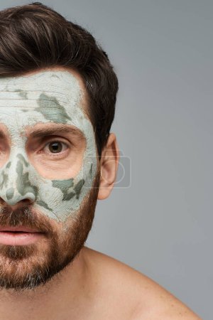 Téléchargez les photos : Beau homme portant un masque facial, soins de la peau. - en image libre de droit