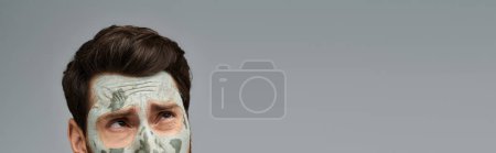 Téléchargez les photos : Charmant homme élégant portant un masque facial, soins de la peau. - en image libre de droit
