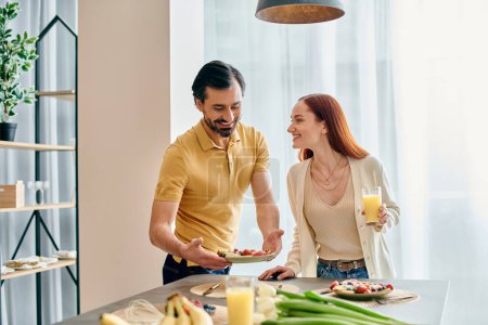 Eine rothaarige Frau und ein bärtiger Mann frühstücken gemeinsam in einer modernen Küche.