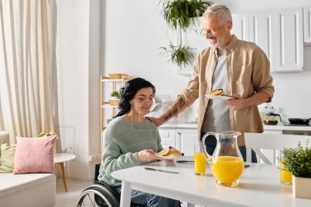 Un hombre en silla de ruedas sirve comida a una mujer en silla de ruedas en su cocina, simbolizando amor y cuidado.