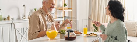 Un homme et une femme handicapée en fauteuil roulant partagent un repas paisible le matin à une table de cuisine confortable dans leur maison.