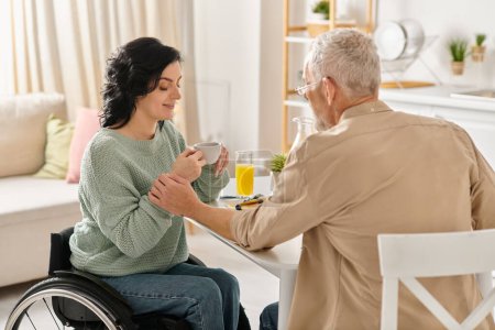 Una mujer en silla de ruedas gentilmente entrega una taza de café cerca del hombre en una cocina en casa.