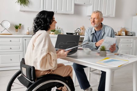 family budget of man and disabled woman reviewing documents at kitchen table