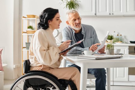 Un hombre y una mujer en sillas de ruedas comparten ideas sobre el presupuesto familiar en un acogedor entorno de cocina.
