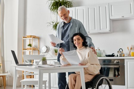 Un hombre y una mujer en silla de ruedas comparten un momento en su cocina en casa, planificación del presupuesto familiar