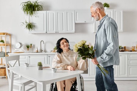 Un hombre tiernamente está junto a su esposa en una silla de ruedas, compartiendo un momento de conexión y apoyo en su cocina en casa.