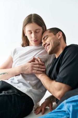Foto de Dos hombres se sientan juntos en una cama, compartiendo un momento de relajación. - Imagen libre de derechos