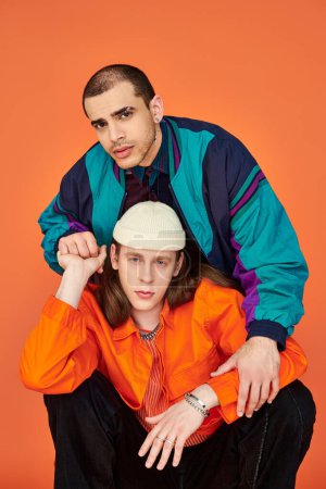 Un hombre con una camisa naranja y un hombre con una chaqueta azul, una pareja gay amorosa.