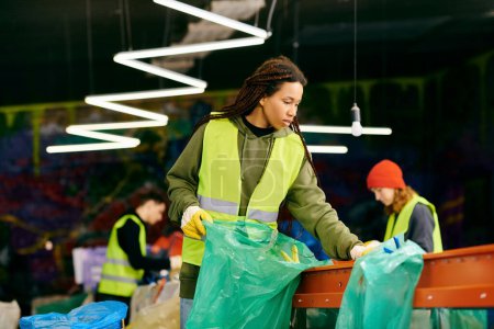 A young volunteer in a green vest is holding a bag while sorting trash with other eco-conscious people.
