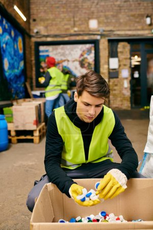 A young volunteer in a yellow vest and gloves sorts through and cleans a box of trash with an eco-conscious attitude.