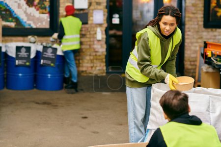 A woman wearing a vibrant yellow jacket, participating in recycling by holding a bowl.