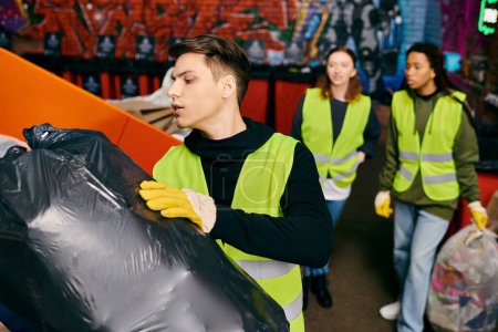 Young volunteers in yellow vests and gloves collaborate to sort trash, carrying a black bag.