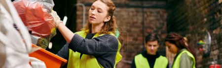 Photo for A young woman in a yellow vest picks up discarded items while volunteering with fellow eco-conscious individuals. - Royalty Free Image